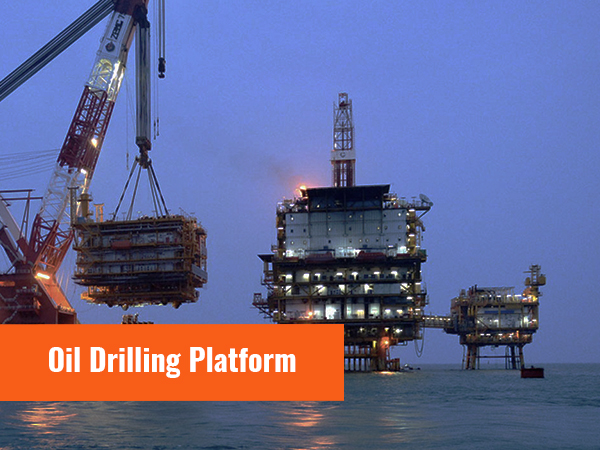 Olieboorplatform op zee met kranen en boorinstallaties tijdens de schemering.